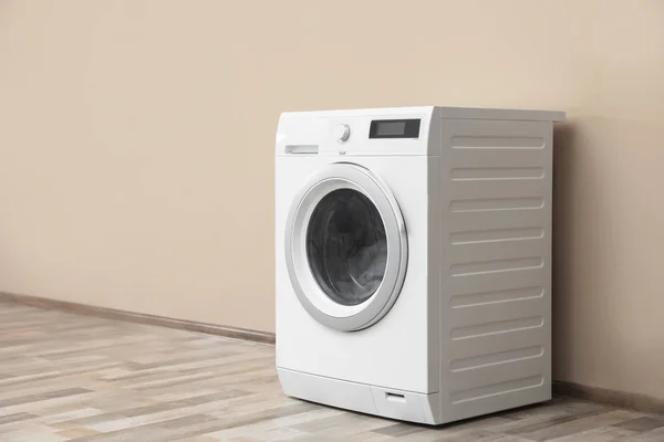 Modern washing machine with laundry near color wall, space for text — Stock Photo, Image