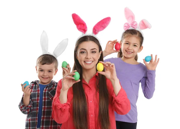 Cute family in bunny ears headbands holding Easter eggs on white background — Stock Photo, Image