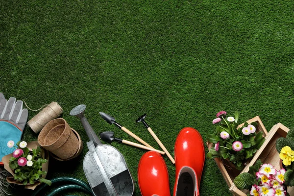 Composizione flat lay con attrezzature da giardinaggio e spazio per il testo su erba verde — Foto Stock