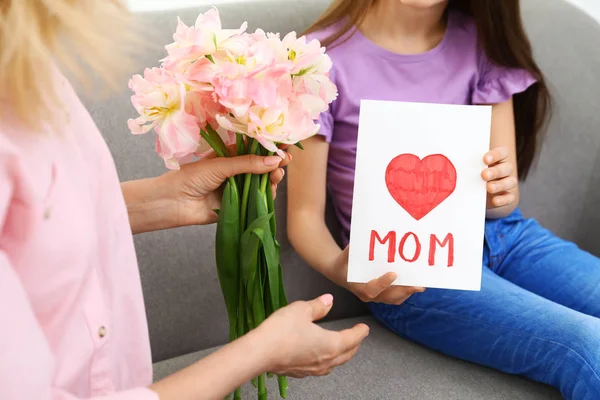 Маленькая дочь поздравляет свою зрелую маму дома, крупным планом. Happy Mother 's Day — стоковое фото