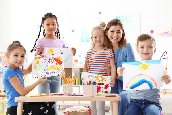 Słodkie dzieci z nauczycielem Wyświetlono ich malowidła w pomieszczeniu lekcji — Zdjęcie stockowe