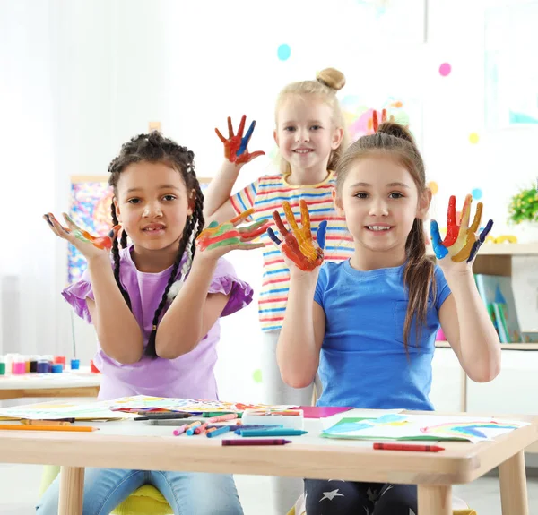 Petits enfants mignons montrant les mains peintes à la leçon à l'intérieur — Photo