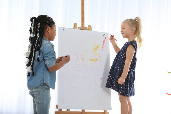 Petits enfants mignons dessin sur chevalet à la leçon de peinture à l'intérieur — Photo