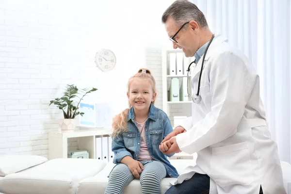 Arzt überprüft im Krankenhaus den Puls des kleinen Mädchens mit den Fingern. Raum für Text — Stockfoto