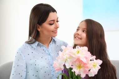 Küçük kızı annesini evde tebrik ediyor. Anneler Günün kutlu olsun.