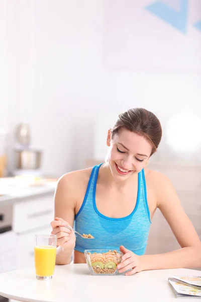 Young woman in fitness clothes having healthy breakfast at home — Stock Photo, Image