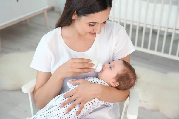 Femme nourrissant son bébé du biberon à la maison — Photo