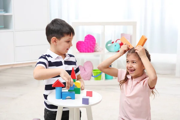 Милые дети играют с красочными блоками дома — стоковое фото