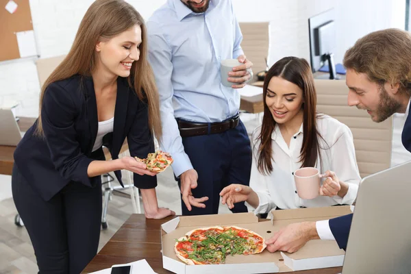 Empleados de oficina comiendo pizza en el lugar de trabajo. Entrega de alimentos — Foto de Stock