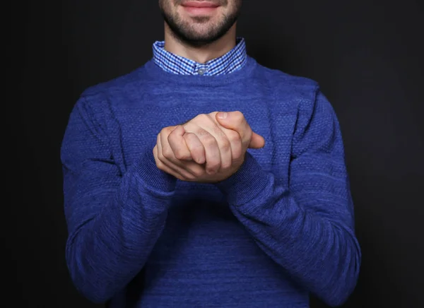 Man showing BELIEVE gesture in sign language on black background, closeup — Stock Photo, Image