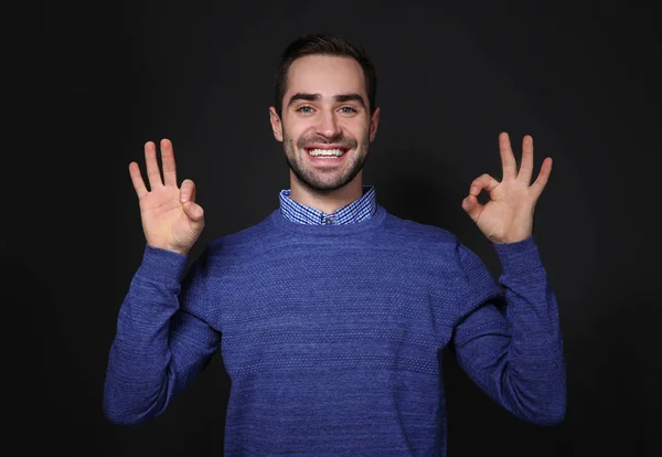 Man showing OK gesture in sign language on black background — Stock Photo, Image