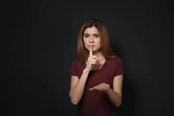 Vrouw toont Hush gebaar in gebarentaal op zwarte achtergrond — Stockfoto