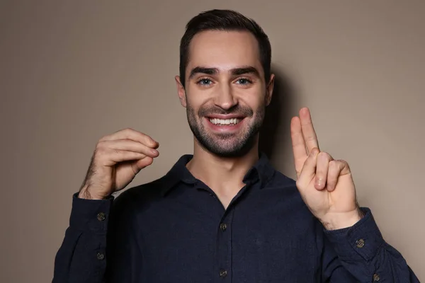 Человек, использующий язык жестов на цветном фоне — стоковое фото