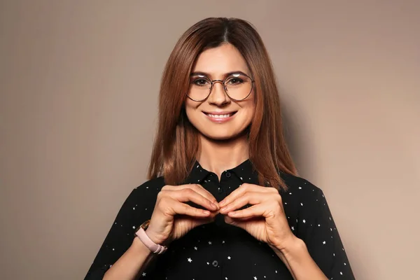 Vrouw met behulp van gebarentaal op kleur achtergrond — Stockfoto