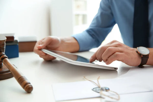 Notarie arbetar med tablett vid bordet i kontor, närbild. Begrepp inom juridik och rättsväsende — Stockfoto