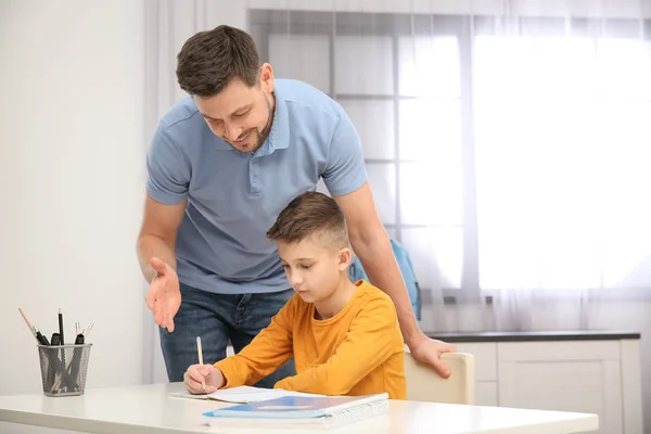 Papá ayudando a su hijo con la tarea en la habitación, espacio para el texto — Foto de Stock