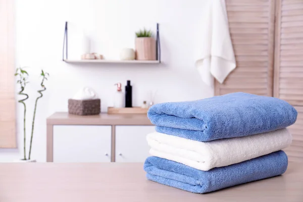 Stack of fresh towels on table in bathroom. Space for text — Stock Photo, Image