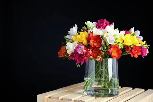 Букет весняних квітів фрезії у вазі на темному тлі. Простір для тексту — стокове фото