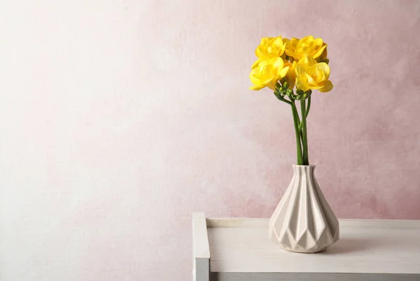 Bouquet di fiori di fresia primaverili in vaso su sfondo a colori. Spazio per testo — Foto Stock