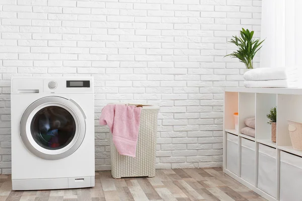 Modern washing machine near brick wall in laundry room interior, space for text — Stock Photo, Image