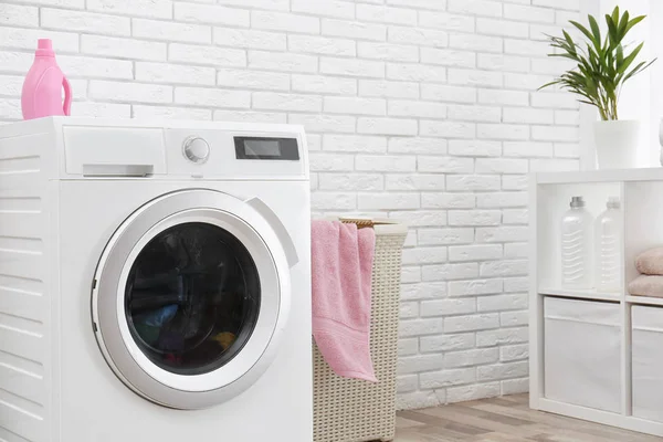 Moderní pračka v blízkosti cihlové stěny v interiérech prádelny, prostor pro text — Stock fotografie