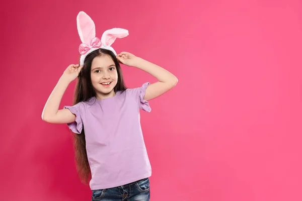 Paskalya bunny kulaklar kafa bandı renk arka plan, metin için yer üzerinde küçük kız portresi — Stok fotoğraf