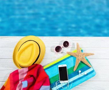 Su yakınında ahşap iskelede plaj aksesuarları ile düz yatıyordu kompozisyon