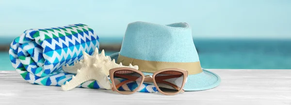 Différents accessoires de plage sur la table contre la mer — Photo