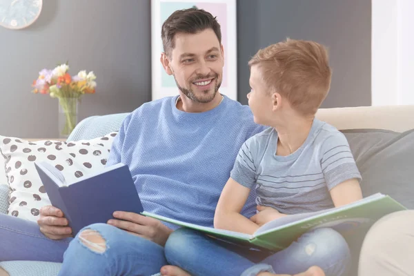 Far och son läser böcker tillsammans hemma — Stockfoto