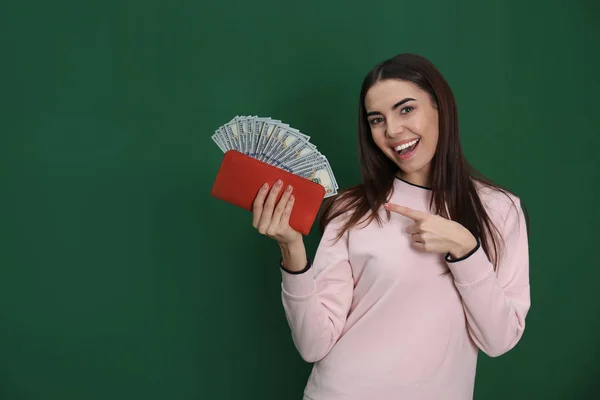 Ung kvinna med pengar i plån bok på färg bakgrund. Utrymme för text — Stockfoto
