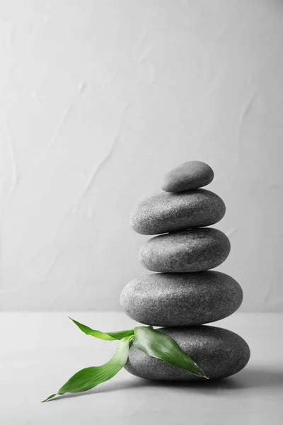 Stack av Zen stenar och bambu blad på bordet mot ljus bakgrund. Utrymme för text — Stockfoto