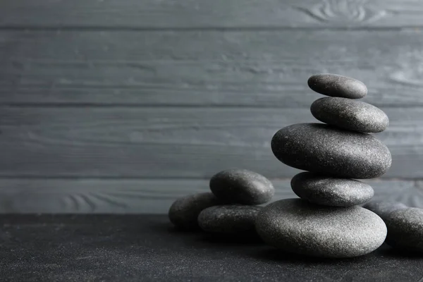 Piedras zen apiladas sobre mesa sobre fondo de madera. Espacio para texto — Foto de Stock