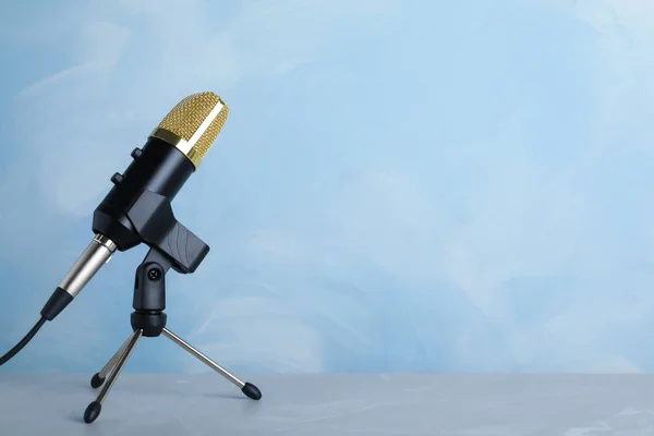 Microphone on table against color background. Space for text — Stock Photo, Image