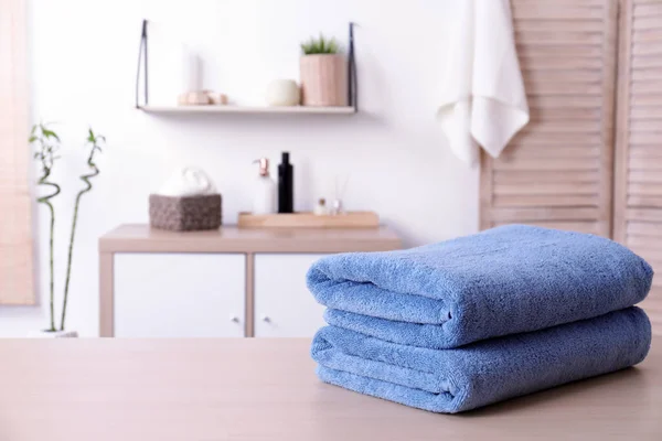 Pilha de toalhas frescas na mesa no banheiro. Espaço para texto — Fotografia de Stock