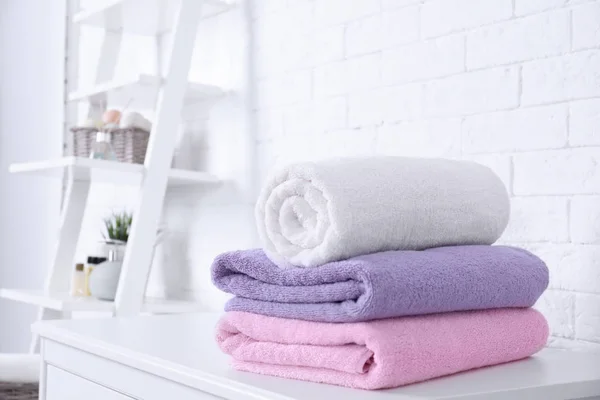 Montón de toallas frescas en la mesa en el baño. Espacio para texto —  Fotos de Stock