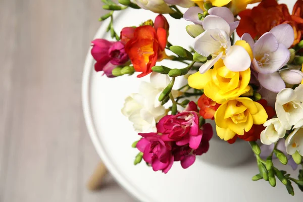 Букет красивих весняних квітів фрезії у вазі на столі. Простір для тексту — стокове фото