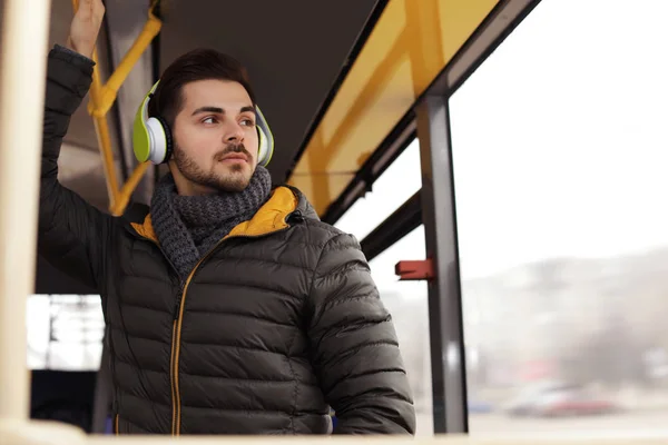 Young man listening to music with headphones in public transport — Stock Photo, Image