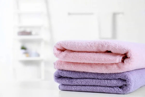 Stack of fresh towels on table in bathroom. Space for text — Stock Photo, Image