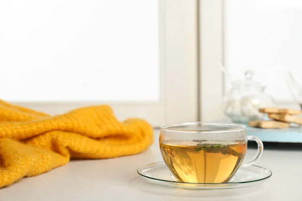 Tasse frischen Tee auf der Fensterbank drinnen, Platz für Text. Wintergetränk — Stockfoto