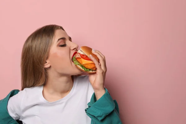 예쁜 여자 색상 배경에서 맛 있는 햄버거를 먹고입니다. 텍스트를 위한 공간 — 스톡 사진