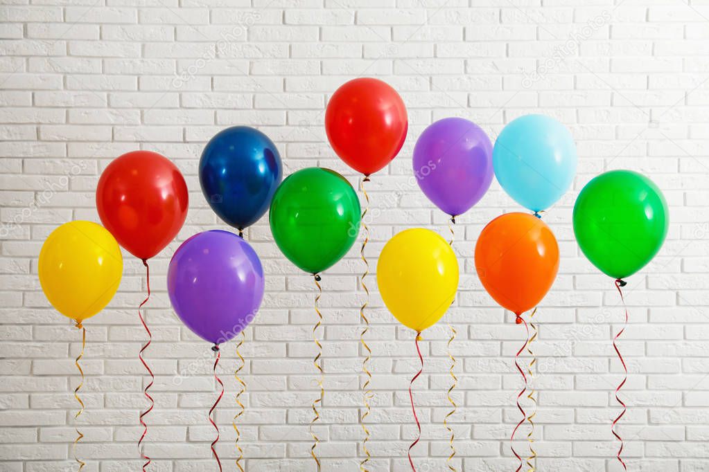 Bright balloons near brick wall. Celebration time
