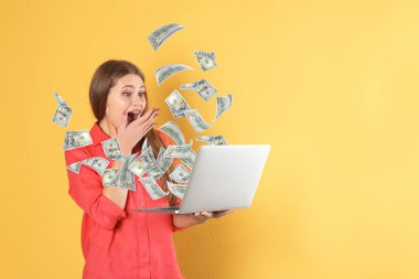 Mutlu kadın laptop zafer kutluyor ve renk arka plan üzerinde Amerikan Doları uçan, metin için boşluk