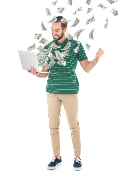 Glücklicher Mann mit Laptop feiert Sieg und fliegende amerikanische Dollars auf weißem Hintergrund — Stockfoto