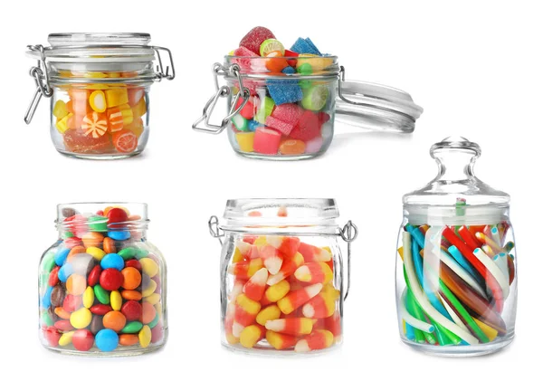 Набор банок с красочными вкусными конфетками на белом фоне — стоковое фото