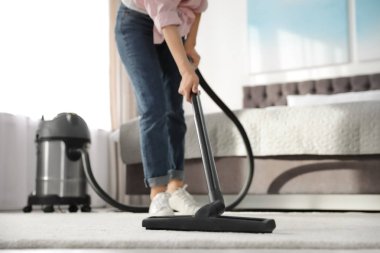 Kadın evde elektrikli süpürge ile halı kir kaldırma, kapatmak