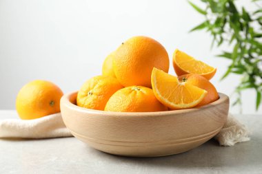 Bulanık arka planda masaya olgun portakallar ile kase