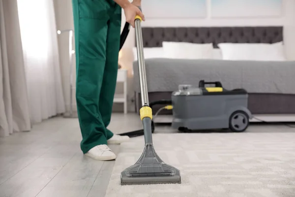 Conserje profesional eliminando la suciedad de la alfombra con aspiradora en el dormitorio, primer plano. Espacio para texto — Foto de Stock