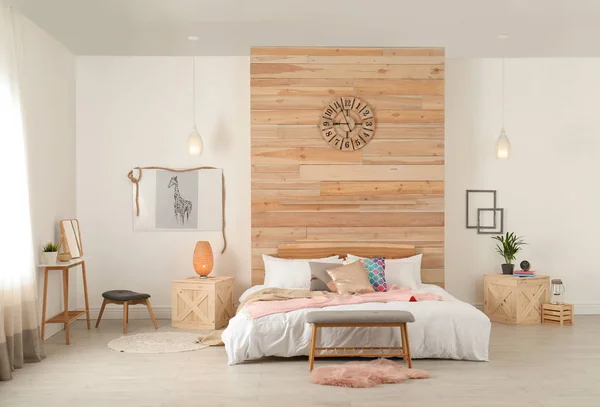 Stylowe wnętrze i wygodne łóżko, blisko ściany drewniane — Zdjęcie stockowe