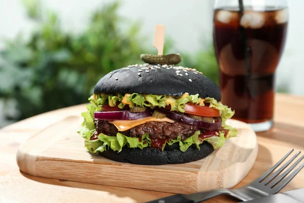 Tafel mit schwarzem Burger auf Holztisch serviert — Stockfoto