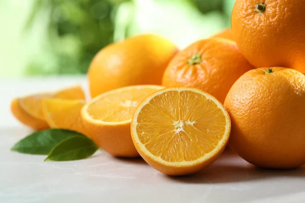 Laranjas maduras na mesa contra fundo desfocado, close-up — Fotografia de Stock